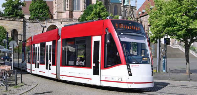 Moderne Straßenbahn in roter und weißer Lackierung auf Domplatz.