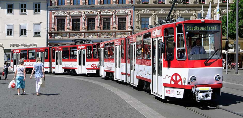 Historische Straßenbahn in roter und weißer Lackierung auf dem Fischmarkt.