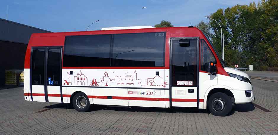 Midi-Bus in roter und weißer Lackierung und der aufgeklebten Silhouette von Erfurt auf dem Betriebshof.
