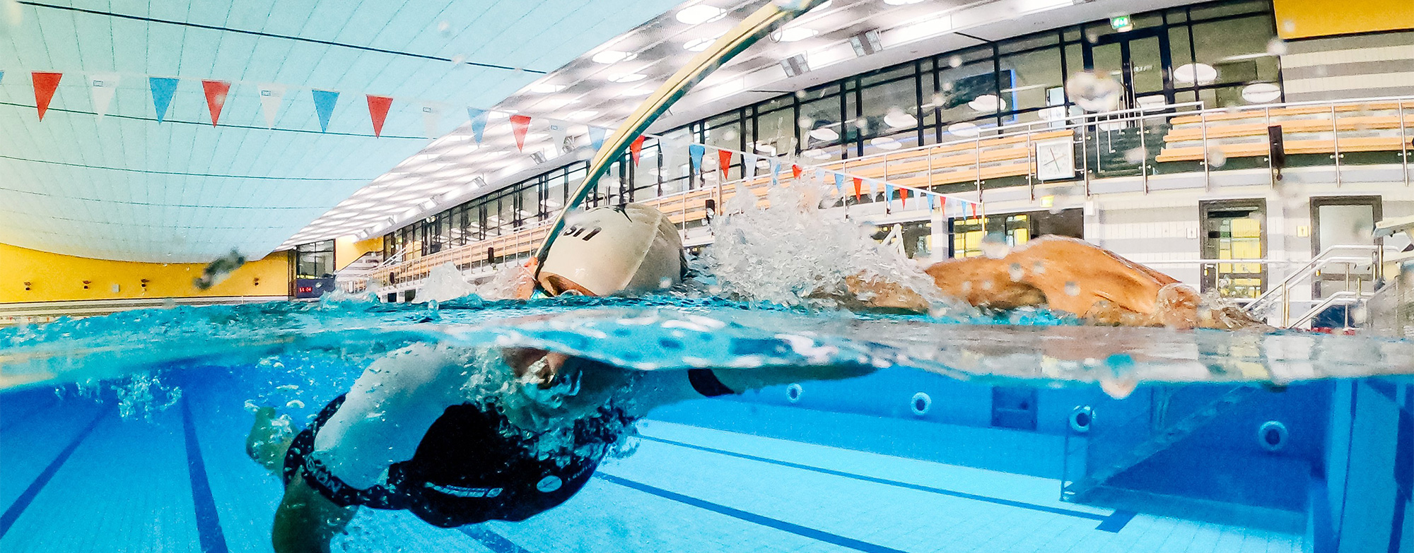 Schwimmer zieht Bahnen in Schwimmhalle